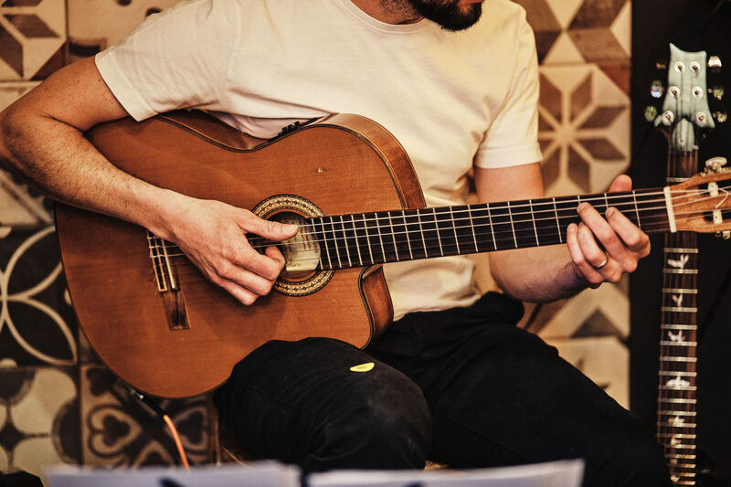 Gitarista hrá živú hudbu počas večera vo Fabrike